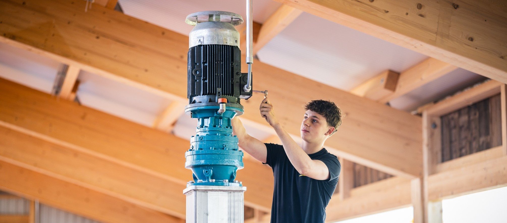Installation eines Elektromotors durch eine Elektrofachperson in einem landwirtschaftlichen oder industriellen Neubau.