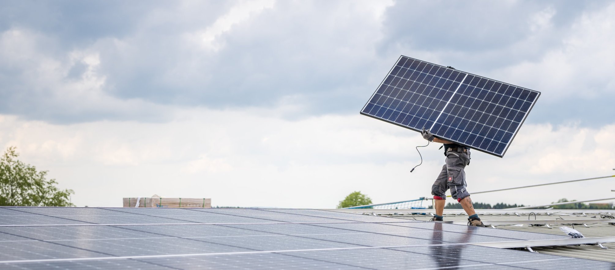 Mitarbeiter der Elektro W&auml;ger AG montiert ein Photovoltaikmodul auf einem Hausdach