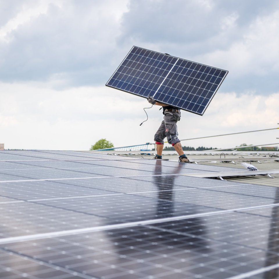 Mitarbeiter der Elektro Wäger AG montiert ein Photovoltaikmodul auf einem Hausdach