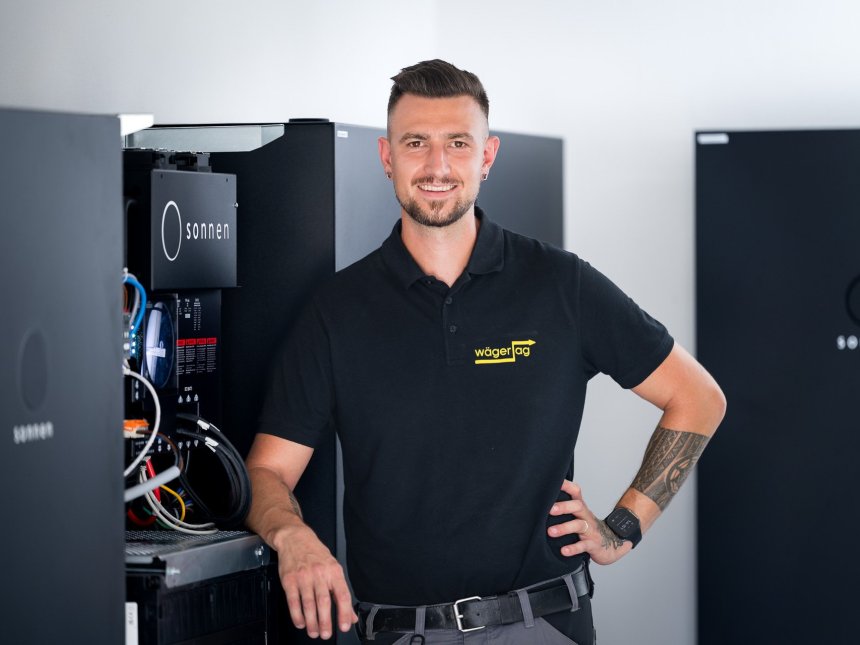 Mitarbeiter steht vor einem Batteriespeicher f&uuml;r das Personalfoto