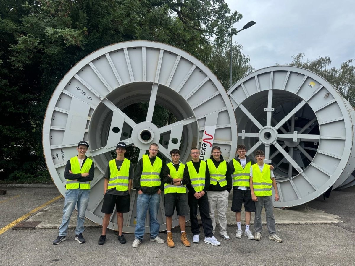 Lernende der Elektro W&auml;ger AG vor einer grossen Kabelbobine