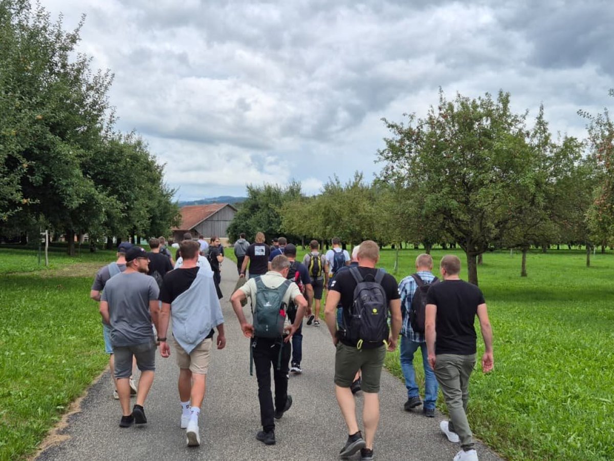 Mitarbeitende der Elektro W&auml;ger AG bei einem gemeinsamen Spaziergang durch die gr&uuml;ne Landschaft beim Sommerausflug